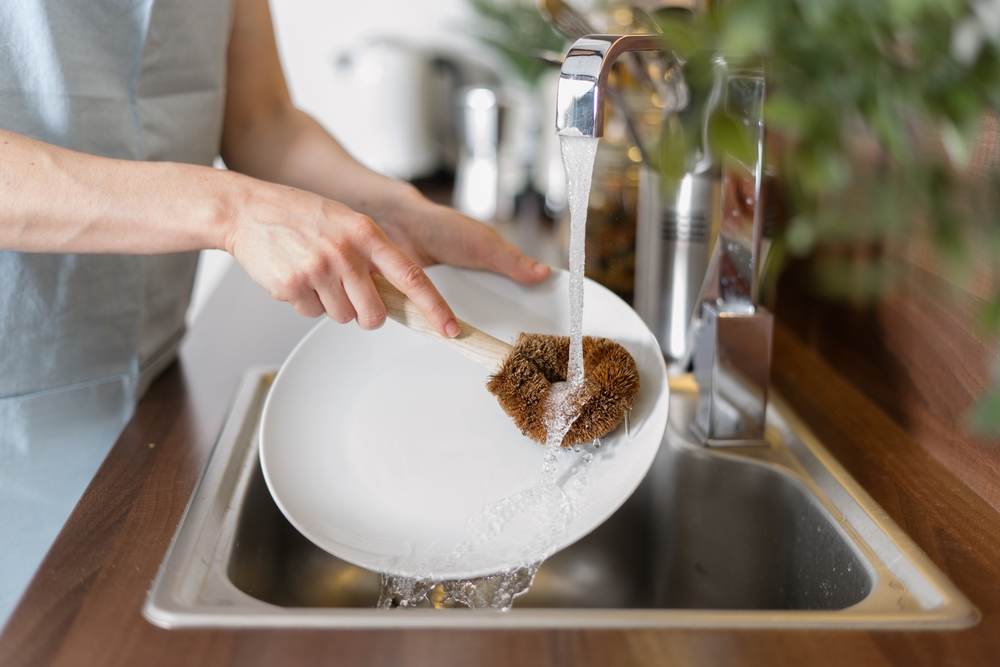 Femme lavant de la vaisselle avec une noix de lavage